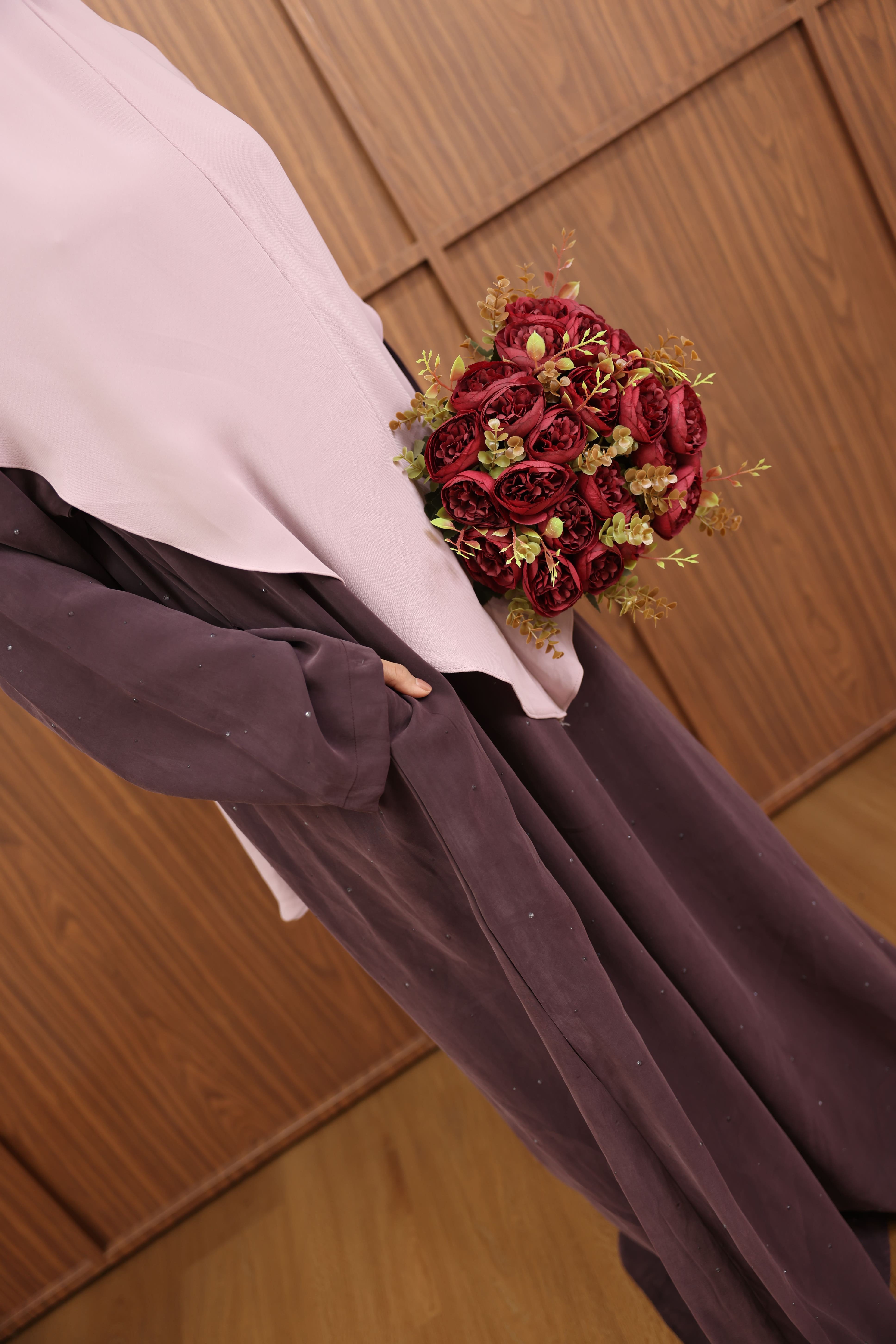 Abaya editorial di bawah lengkungan sandstone